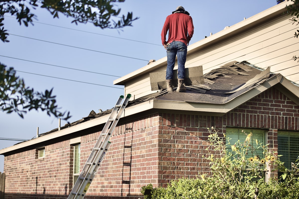 Roofing contractor inspecting storm damage for insurance claim